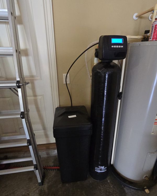 Clack WS1 softener installed beside a water heater in a garage
